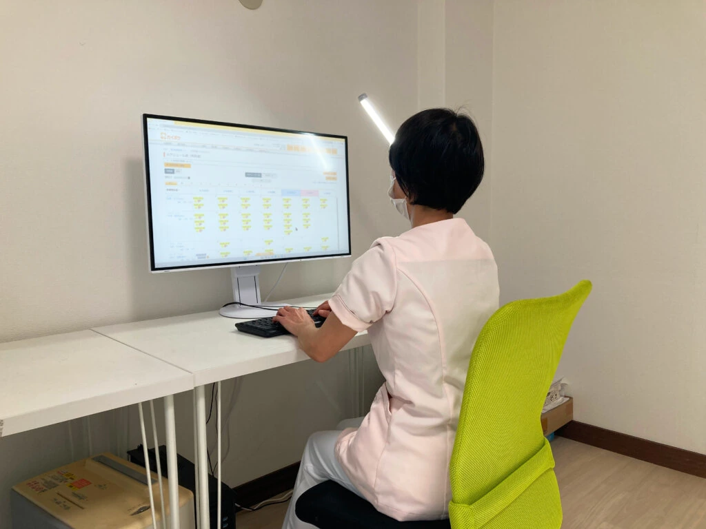 パソコンで記録を確認するスタッフ